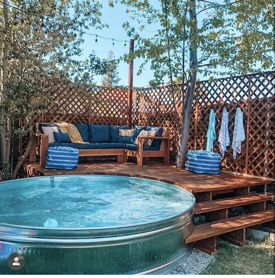 Stock tank pool rond en acier galvanisé, installé et rempli dans un jardin